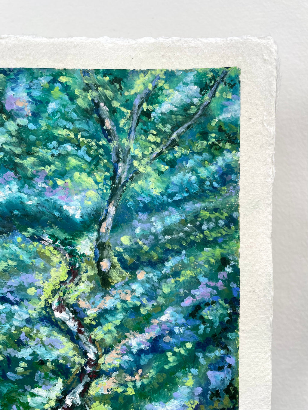 A close-up of a textured oil pastel painting depicting a lush green tree with blue and purple undertones.