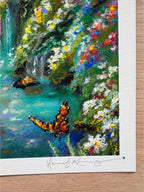 Close-up detail of whimsical forest giclée print showing orange butterfly, vibrant blue water, foreground wildflowers, and hand-signed pencil signature.