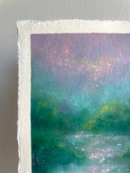 A close-up of a textured painting showing a semi abstract landscape with teal, green, purple, and pink tones, photographed against a light gray wall.
