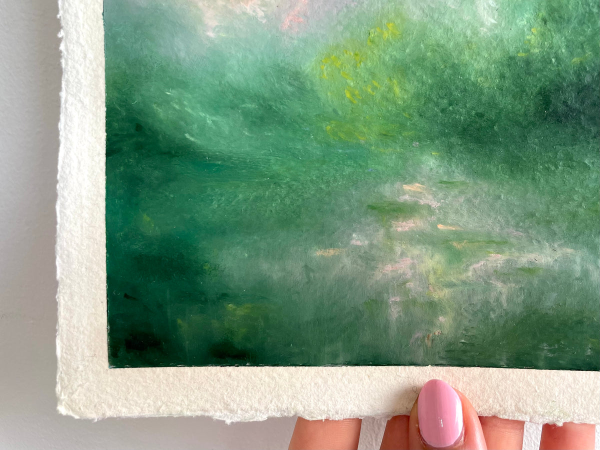 A close-up of a semi abstract mystical green landscape, held at the bottom by a hand.