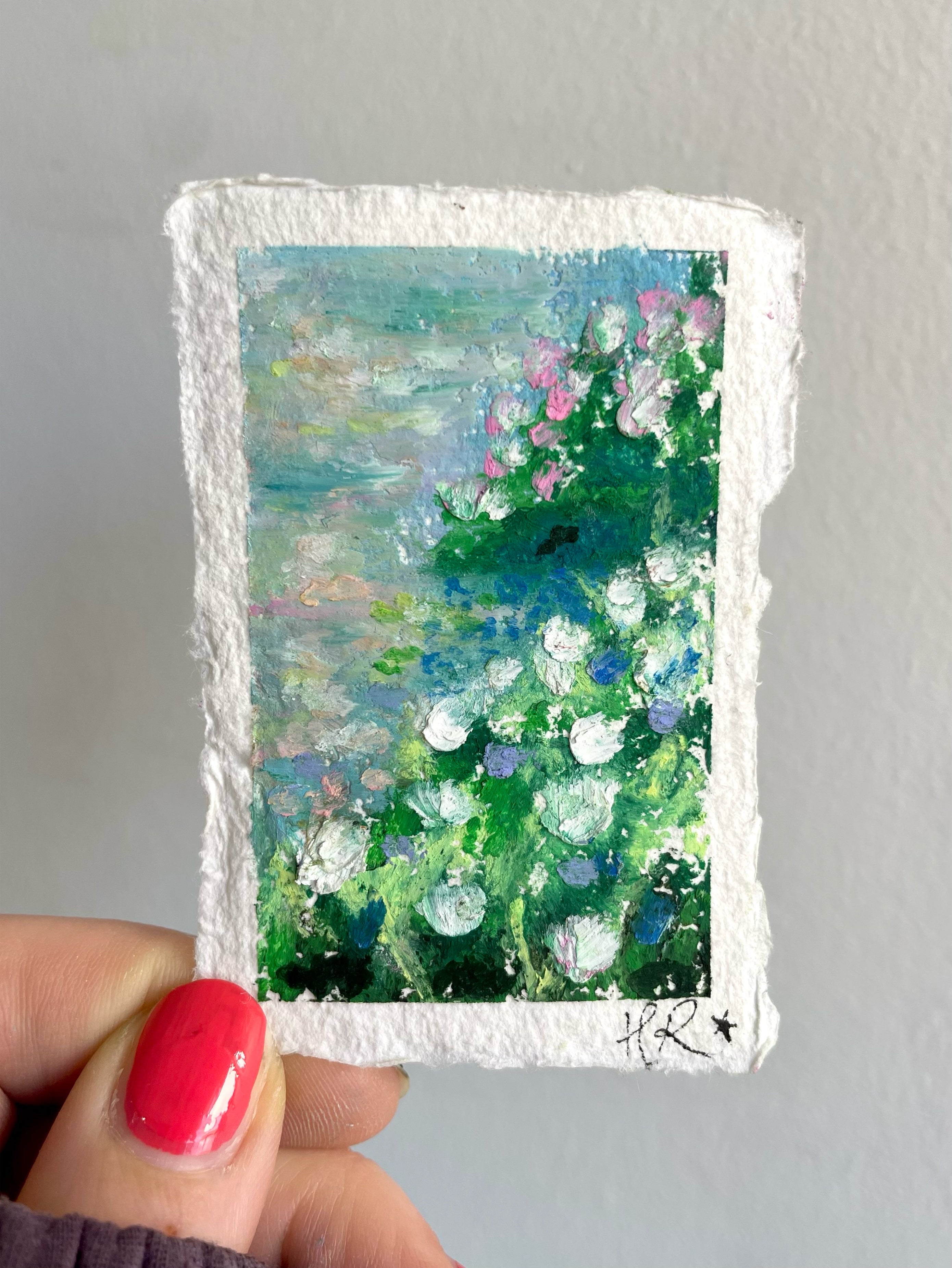 Mini original oil pastel landscape painting featuring detailed floral riverbank scene with soft natural textures and peaceful magical scenery.