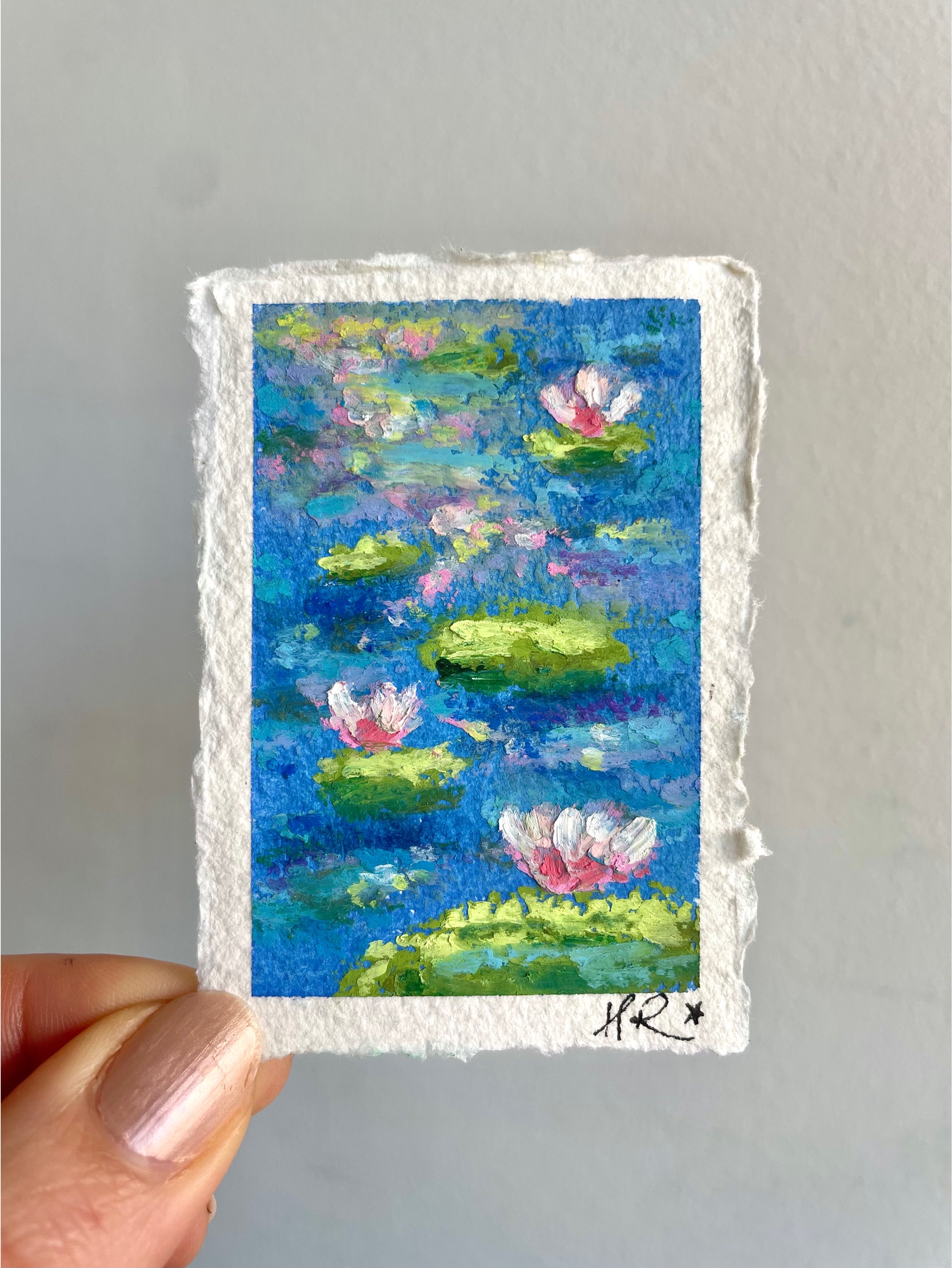 Whimsical mini oil pastel pond painting featuring vibrant blue, pink, and green tones with water lilies, lily pads, and shimmering sunlight reflections.