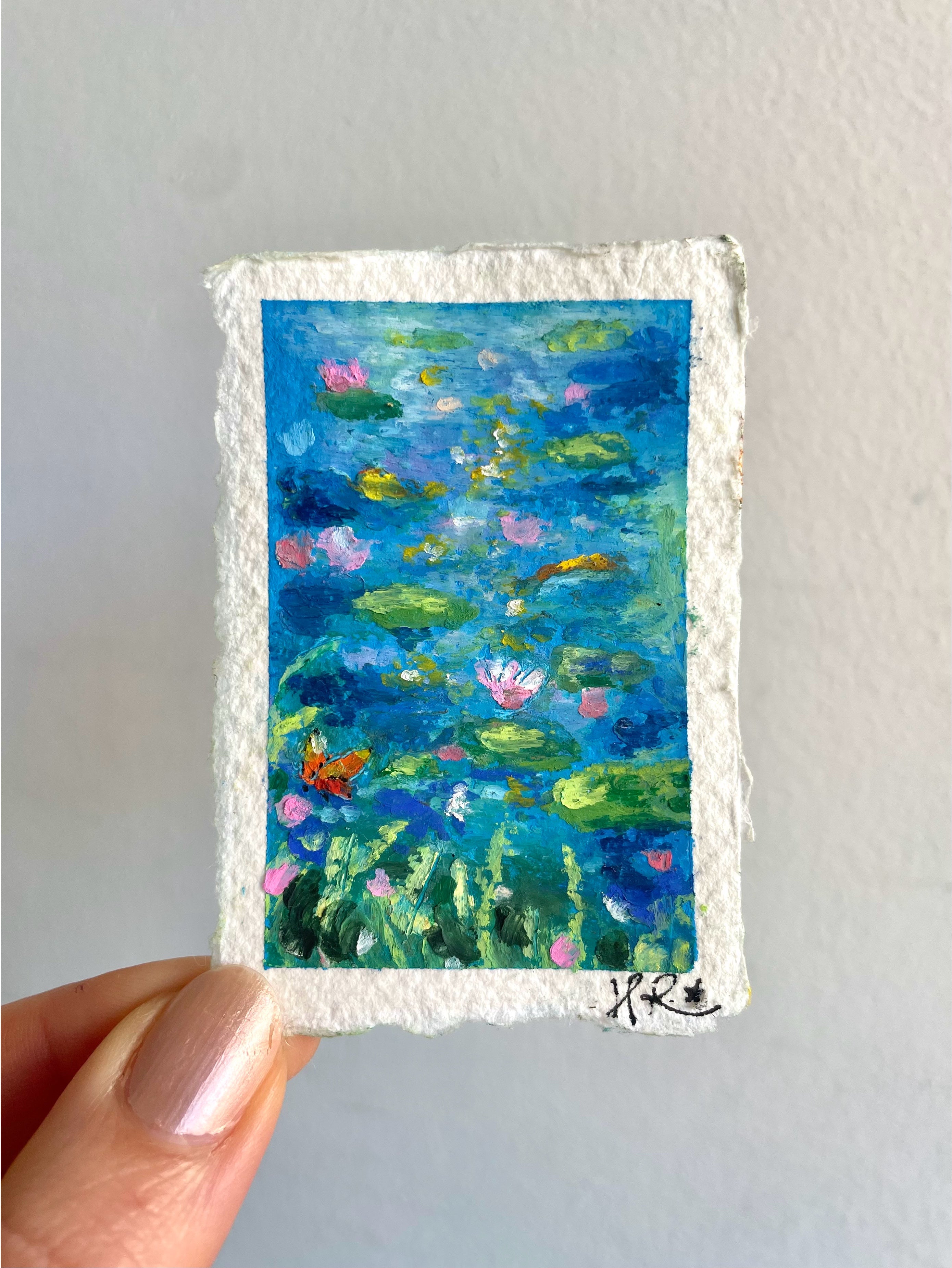 Detailed mini oil pastel pond painting featuring tiny lily pads, orange butterfly, koi fish, wildflowers, and shimmering sunlight reflections.
