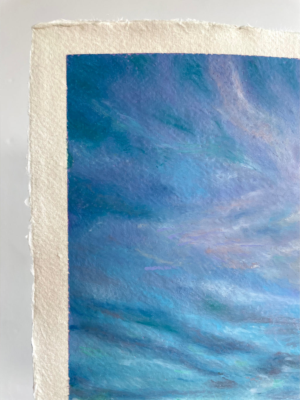 Close-up detail of whimsical oil pastel sky showing rich blue and purple tones with soft drifting clouds above a wildflower landscape.