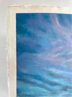 Close-up detail of whimsical oil pastel sky showing rich blue and purple tones with soft drifting clouds above a wildflower landscape.