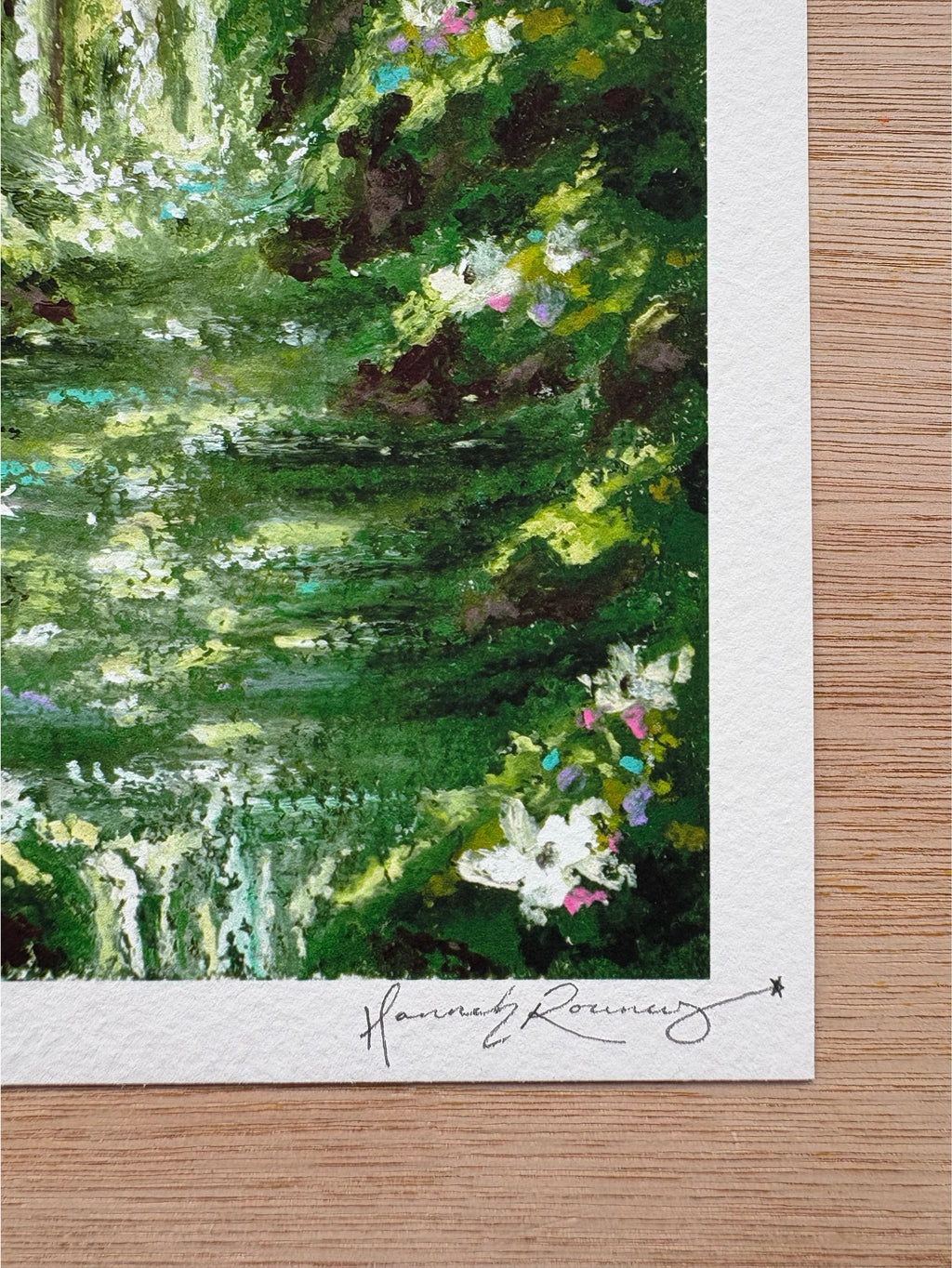 Close-up detail of enchanted forest giclée print showing foreground waterfall, white wildflowers, and hand-signed pencil signature.