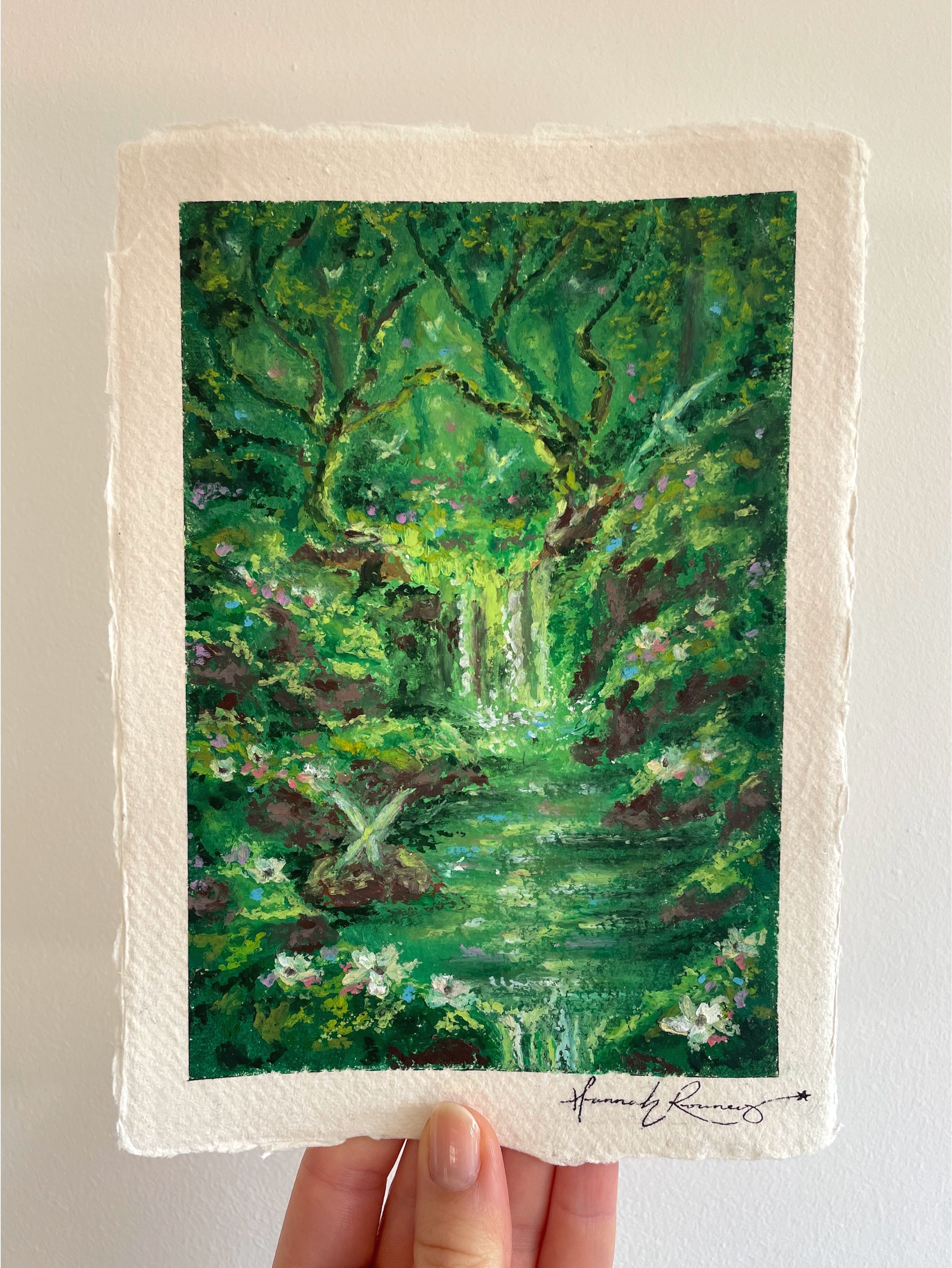 Original enchanted forest oil pastel painting held in hand, inspired by Celtic folklore with fairies, moss-covered trees, emerald green woodland, and magical textured detail.
