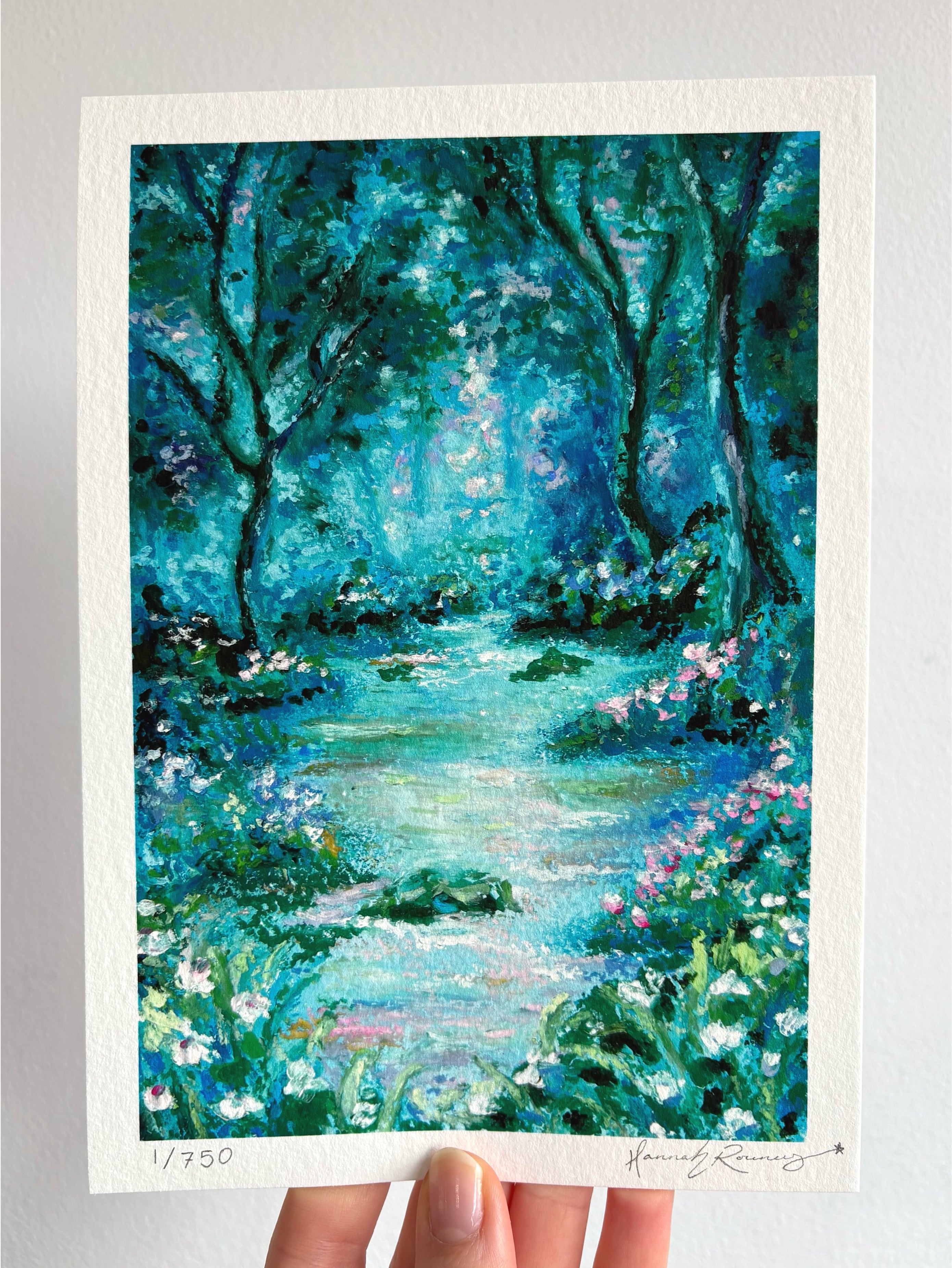 Limited edition hand-signed giclée fine art print of glowing mystical forest landscape with river, wildflowers, and ancient trees held against a white wall.
