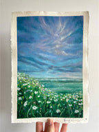 Whimsical oil pastel landscape painting featuring a wildflower meadow beneath a striking blue and purple sky with soft drifting clouds and dreamy atmosphere.