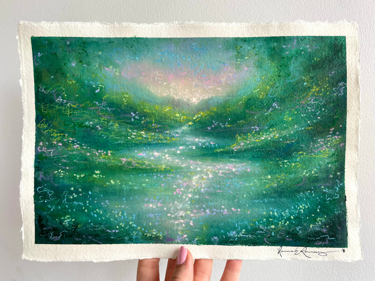A textured, hand-painted semi-abstract landscape original painting featuring shades of green, teal, and blue with sparkling light details, held by a hand against a white wall.